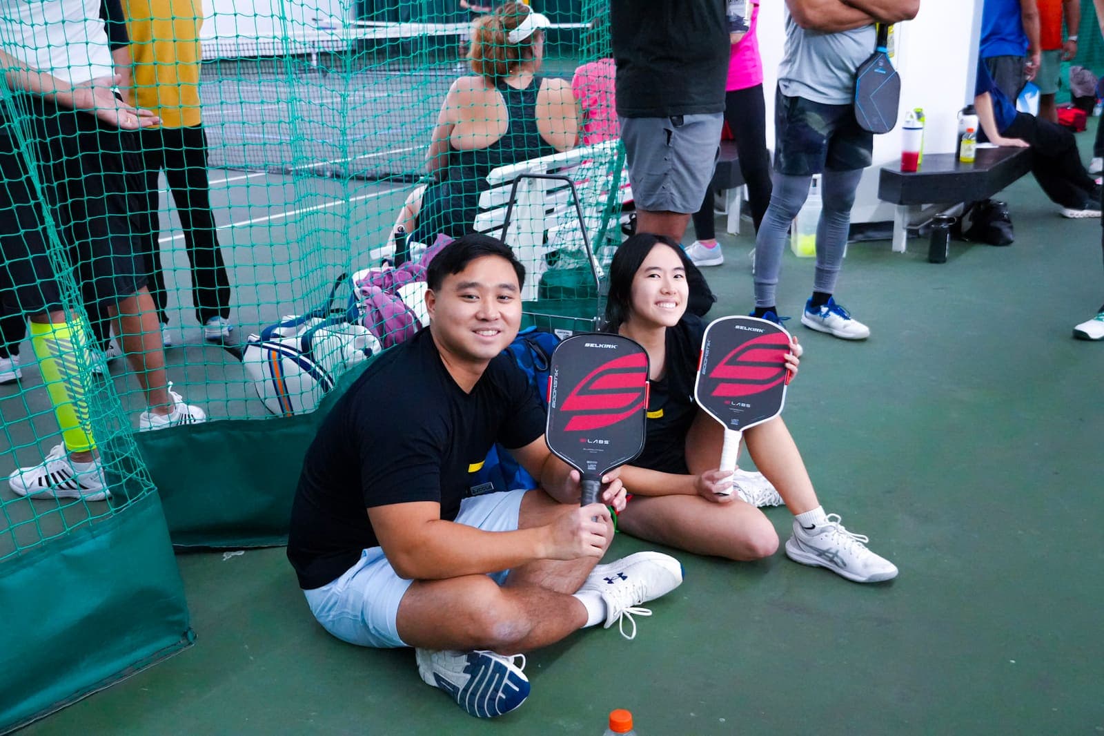 Two CourtQuest players posing with their paddles